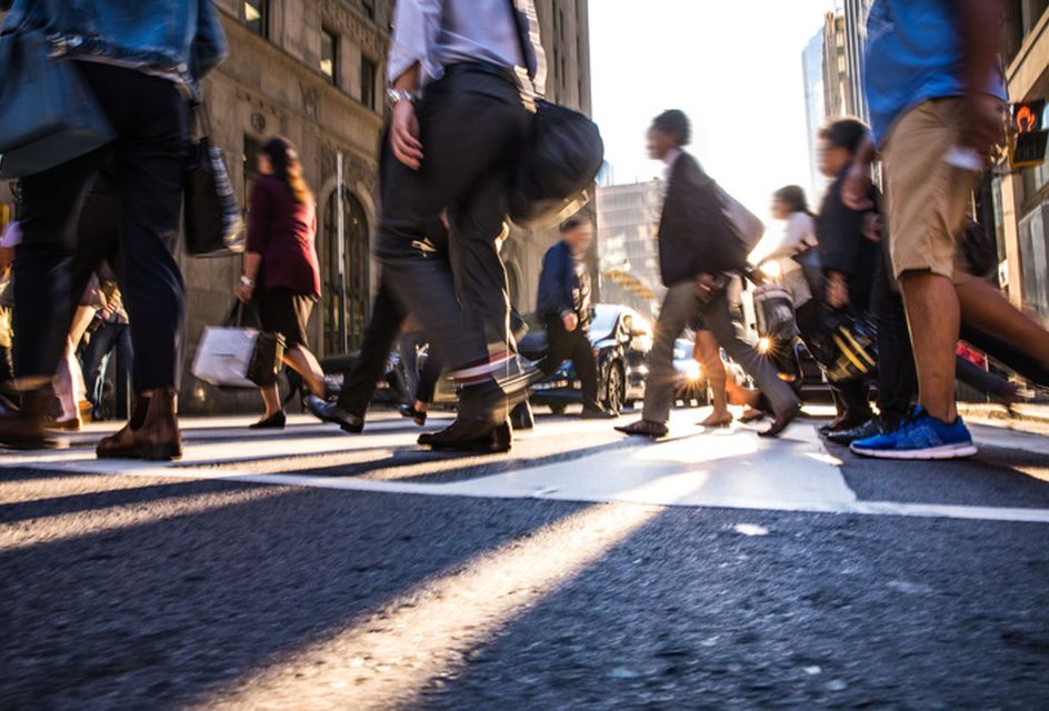 A crowd of people walking across a city street