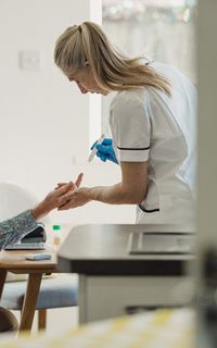 A healthcare worker treating an older man