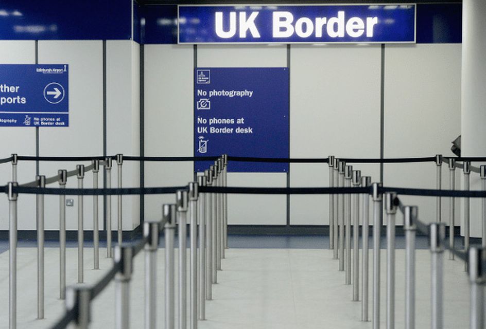 The entrance to UK border control, with a sign reading "UK Border" and barriers set up for queuing.