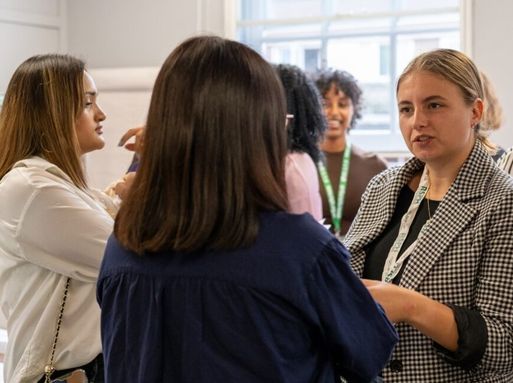 A group of three women at a professional RSPH event engaged in conversation.