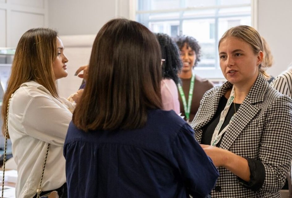 A group of three women at a professional RSPH event engaged in conversation.