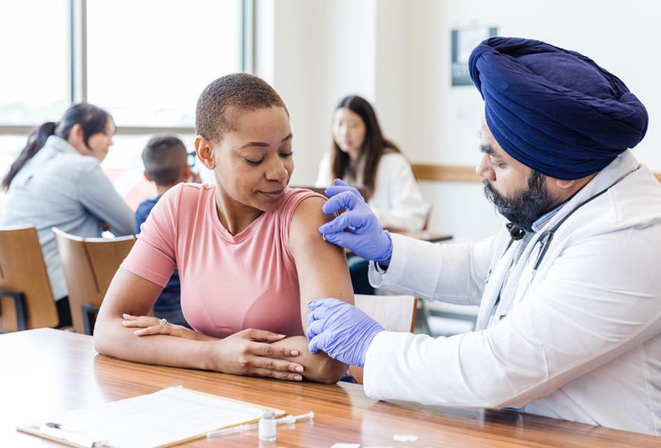 Woman receiving a vaccination from a doctor