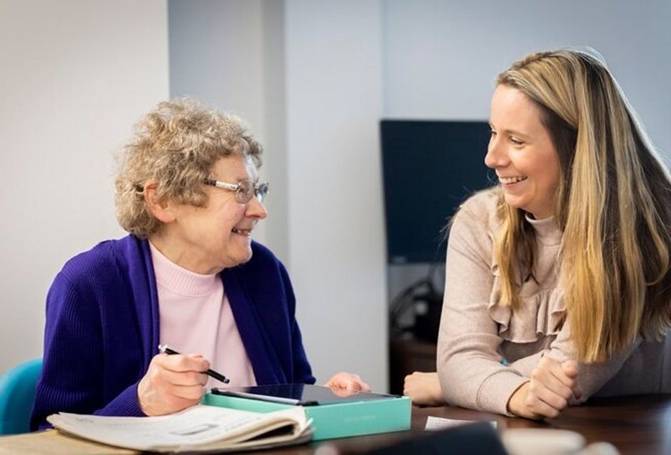 An elderly woman and a younger woman talking