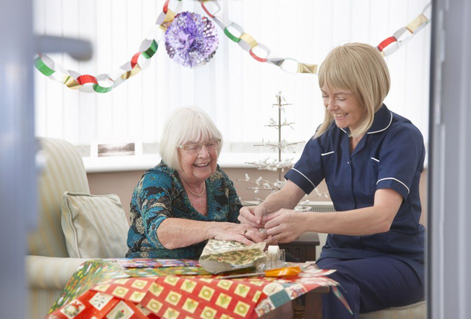 An adult social care nurse celebrating with a patient