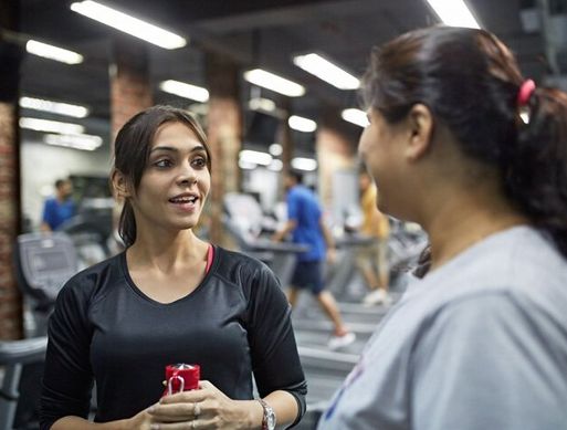 Two women talking in a gym
