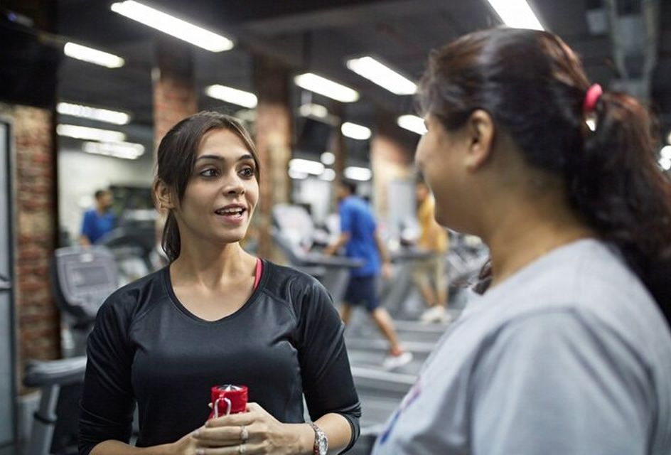 Two women talking in a gym